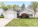 Charming one-story home featuring a garage, landscaped front yard, and manicured lawn at 12628 Waterfall Pl, Charlotte, NC 28278