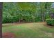 Expansive backyard with manicured lawn and outdoor pavilion and fireplace, nestled among mature trees at 1305 Anniston Pl, Wesley Chapel, NC 28079