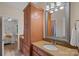 Well-lit bathroom featuring granite countertops, a large mirror, and modern fixtures at 1305 Anniston Pl, Wesley Chapel, NC 28079
