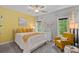 Cozy bedroom with yellow accent wall, large windows, and comfortable furnishings at 1305 Anniston Pl, Wesley Chapel, NC 28079