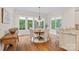 Bright breakfast nook with a round table, seating for four and a view of wooded back yard at 1305 Anniston Pl, Wesley Chapel, NC 28079