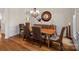 Formal dining room showcasing hardwood floors, stylish chairs, and a decorative mirror create an inviting space at 1305 Anniston Pl, Wesley Chapel, NC 28079