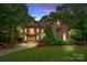 Elegant stone-front home with manicured lawn and mature trees, showcasing curb appeal and architectural details at 1305 Anniston Pl, Wesley Chapel, NC 28079