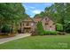 Stunning stone and brick home with a manicured lawn and lush landscaping, exuding curb appeal at 1305 Anniston Pl, Wesley Chapel, NC 28079