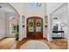Elegant foyer features a hardwood floor, a round rug, a wooden front door, and stylish sconces at 1305 Anniston Pl, Wesley Chapel, NC 28079
