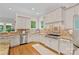 An all-white kitchen featuring granite countertops, stainless steel appliances and hardwood floors at 1305 Anniston Pl, Wesley Chapel, NC 28079