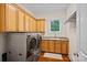Laundry room with modern washer and dryer, storage cabinets, and utility sink at 1305 Anniston Pl, Wesley Chapel, NC 28079