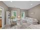 Bright living room featuring a white sofa, desk, large windows and ample natural light at 1305 Anniston Pl, Wesley Chapel, NC 28079