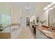 Luxurious main bathroom featuring double vanities, soaking tub, walk-in shower, and elegant chandelier at 1305 Anniston Pl, Wesley Chapel, NC 28079