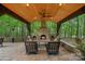 Inviting outdoor living space with stone fireplace and comfortable seating overlooking lush greenery at 1305 Anniston Pl, Wesley Chapel, NC 28079