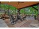 Beautiful outdoor area featuring a stone fireplace, covered patio with seating, and a view of the backyard at 1305 Anniston Pl, Wesley Chapel, NC 28079