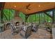 Cozy outdoor fireplace with comfortable seating area and wood ceiling, perfect for outdoor gatherings at 1305 Anniston Pl, Wesley Chapel, NC 28079