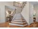Elegant staircase featuring wood treads, white risers, and iron railing at 1305 Anniston Pl, Wesley Chapel, NC 28079