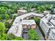 An aerial view of a brick apartment building surrounded by lush trees and neighboring buildings at 1323 Queens Rd # 420, Charlotte, NC 28207