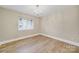 Bright bedroom with a chandelier, hardwood floors, and a large window, creating a serene, spacious environment at 1323 Queens Rd # 420, Charlotte, NC 28207