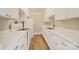 Bright galley kitchen featuring white cabinets, modern gold hardware, and new countertops, providing a clean, stylish space at 1323 Queens Rd # 420, Charlotte, NC 28207