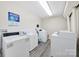 Modern laundry room featuring multiple washing machines and a sink at 1323 Queens Rd # 420, Charlotte, NC 28207