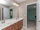 Bathroom featuring double sinks, modern fixtures, cherry cabinets and a view into an adjacent bedroom at 140 Halifax Dr, Fort Mill, SC 29707