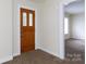 Entryway with a wood door, carpet flooring, and view into the living room at 166 Still Ave, Fort Mill, SC 29715
