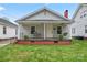 Inviting front porch with swing, seating, and plants on a well-kept lawn at 18 Douglas Nw Ave, Concord, NC 28025