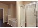 Bathroom features a shower with glass door, soaking tub, and neutral color palette at 18711 Ruffner Dr # 1A, Cornelius, NC 28031