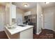 Modern kitchen with quartz counters, stainless steel appliances, white cabinets and breakfast bar at 18711 Ruffner Dr # 1A, Cornelius, NC 28031