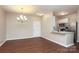 Open concept living area with modern lighting, wood floors, and kitchen bar at 18711 Ruffner Dr # 1A, Cornelius, NC 28031