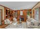 Charming living room featuring wood paneling, built-in shelves, and a cozy fireplace at 1949 S Wendover Rd, Charlotte, NC 28211