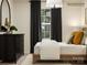 This bedroom shows a dark dresser with plants, a well lit window, and decorative pillows on the bed at 2112 Columbidae Ln, Gastonia, NC 28052