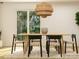 Inviting dining room with a stylish chandelier, a natural wood table, and sliding glass doors to the backyard at 2112 Columbidae Ln, Gastonia, NC 28052