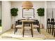 Dining room featuring a modern table and chairs beneath a unique woven light fixture, flanked by green plants at 2112 Columbidae Ln, Gastonia, NC 28052