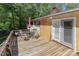 Back deck features an umbrella-covered table and chairs with views of mature trees and landscaping at 212 Davies Cir, Cleveland, NC 27013
