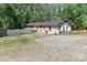 Charming exterior with gravel driveway, mature trees and two front doors at 212 Davies Cir, Cleveland, NC 27013