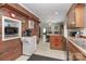 Open-concept kitchen with brick wall, wood cabinets, and eat-in counter, seamlessly connecting to dining area at 212 Davies Cir, Cleveland, NC 27013