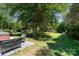 Relaxing backyard featuring patio furniture and a lush lawn shaded by mature trees for tranquil outdoor enjoyment at 2278 Jon Chris Dr, Harrisburg, NC 28075