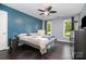 This primary bedroom has a blue accent wall, hardwood floors, and two windows at 2278 Jon Chris Dr, Harrisburg, NC 28075