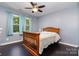 The hardwood-floored bedroom has a ceiling fan and a large window with curtains at 2278 Jon Chris Dr, Harrisburg, NC 28075