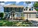 Charming two-story home with blue siding, manicured lawn and attached two-car garage on a sunny day at 2278 Jon Chris Dr, Harrisburg, NC 28075