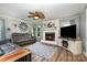 Cozy living room featuring a stylish fireplace, a ceiling fan, and comfortable leather seating at 2278 Jon Chris Dr, Harrisburg, NC 28075