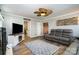 Open-concept living room with modern decor, a ceiling fan and sleek gray sofa for entertaining at 2278 Jon Chris Dr, Harrisburg, NC 28075