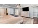 Spacious bedroom with neutral paint, hardwood floors, tray ceiling, and ensuite bathroom at 2278 Jon Chris Dr, Harrisburg, NC 28075
