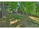 The spacious backyard is framed by a wooden fence, lush trees and the wooden staircase to a firepit at 2544 Barrington Ct, Rock Hill, SC 29732