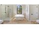 Bright bathroom featuring a soaking tub and glass enclosed shower under a large window at 2544 Barrington Ct, Rock Hill, SC 29732
