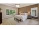 Bedroom featuring a king bed with decorative pillows and a wood accent wall bathed in natural light from large windows at 2544 Barrington Ct, Rock Hill, SC 29732