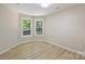 Comfortable bedroom with neutral walls, light wood flooring, and two windows offering pleasant views of the outdoors at 2544 Barrington Ct, Rock Hill, SC 29732