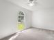 A bright bedroom with a ceiling fan and a large arched window overlooking the front yard at 318 Huffman Rd, Gastonia, NC 28056
