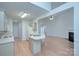 Well-lit kitchen features center island, hardwood floors, white appliances, and open layout at 3226 Chatfield Sw Ln, Concord, NC 28027