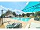 Community pool with lounge chairs and umbrellas for relaxing and enjoying the sunny weather at 3226 Chatfield Sw Ln, Concord, NC 28027