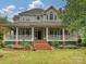 Stunning two-story home boasting a charming wrap-around porch with beautiful landscaping and an inviting entrance at 3231 Karen Ln, Monroe, NC 28110