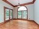 Beautiful living room with wood floors, trim, large arched window, and glass doors at 3231 Karen Ln, Monroe, NC 28110